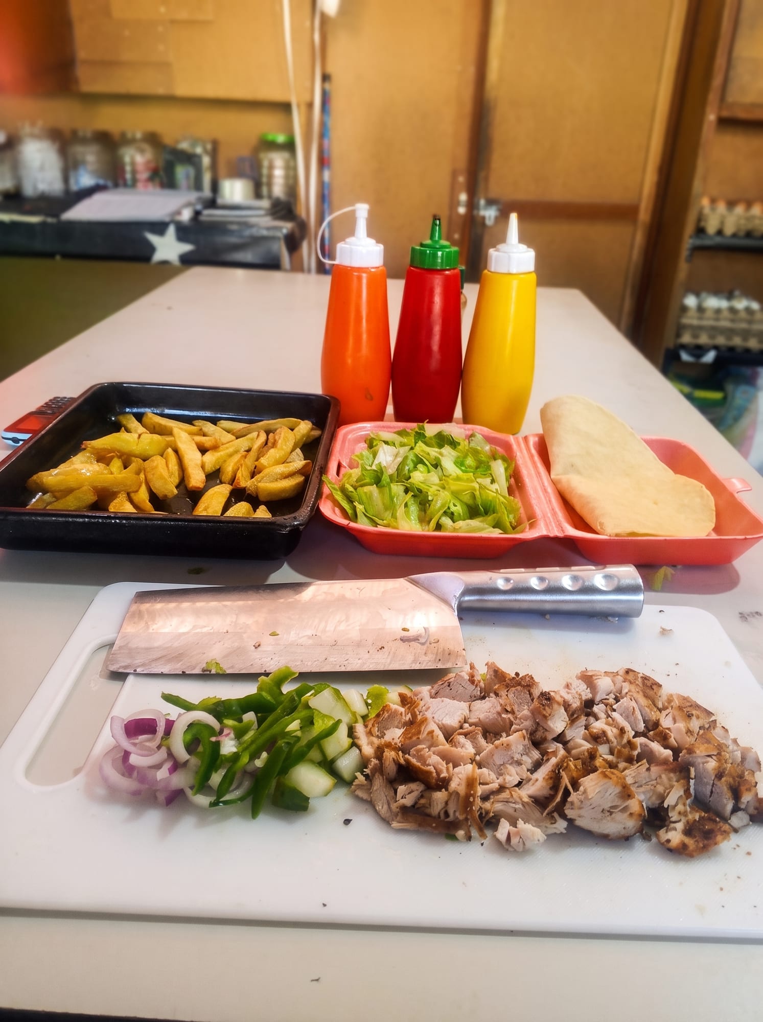 Prepping fresh shawarma, fries, and salads in the Queso Pizza kitchen